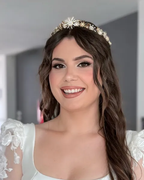 Novia con diadema de estrellas, el pelo largo ondulado y mangas de encaje